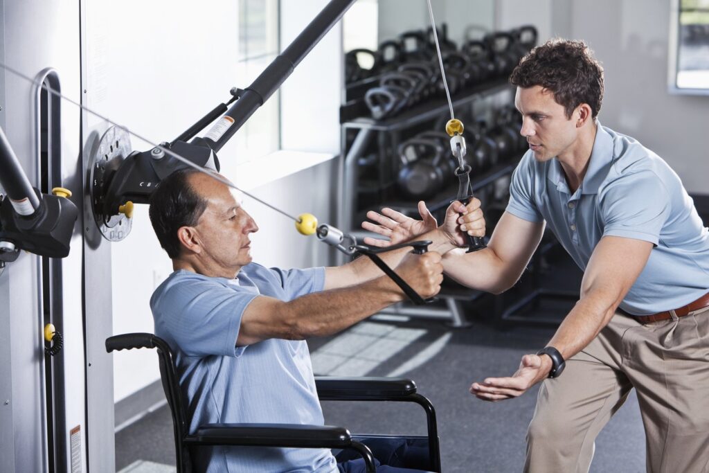 Physical therapist helping patient in wheelchair